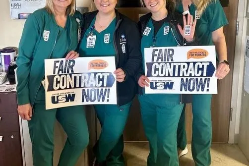 SLH workers holding Fair Contract Now signs