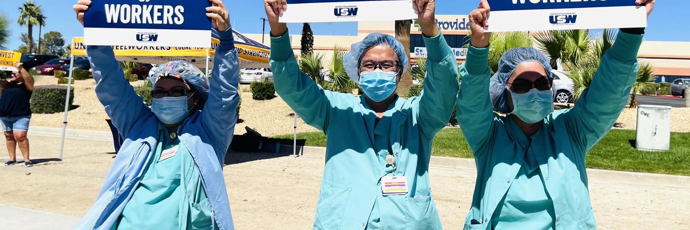 nurses outside holding signs of worker solidarity