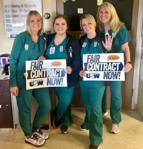 SLH workers holding Fair Contract Now signs