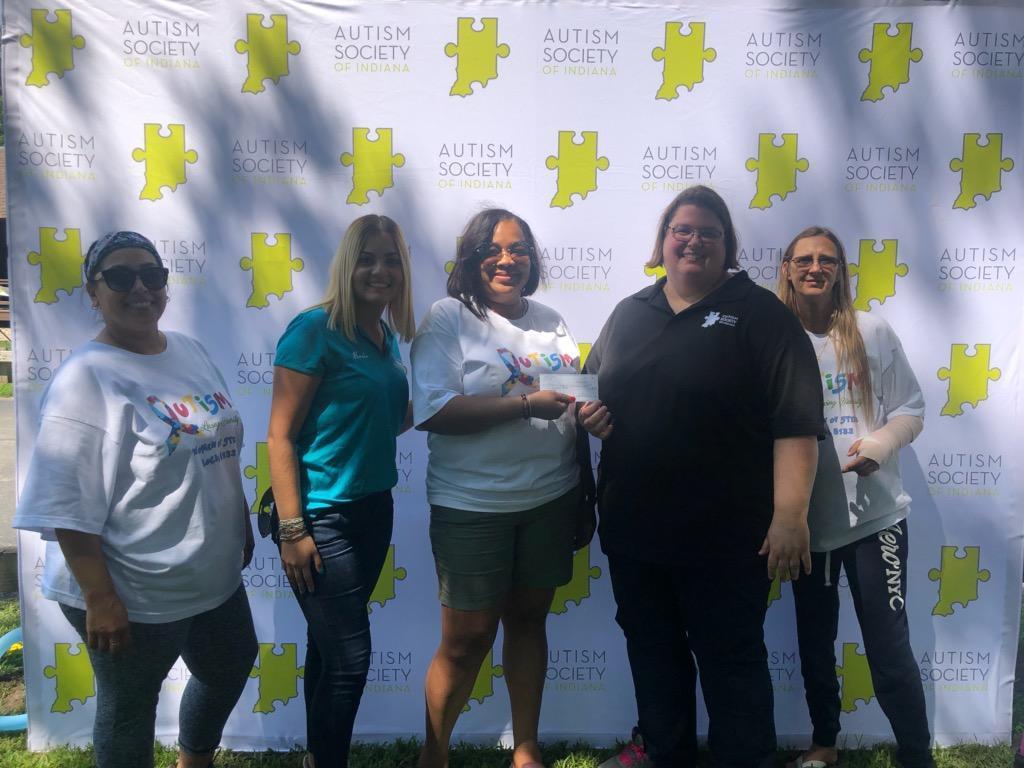 WOS President Tamika Malone presenting check to Autism Coordinator of Walk