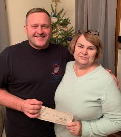 Karen Prim of Harrisville Baptist Church accepting donation for Angel Tree Program from USW 499 member Danny Summers